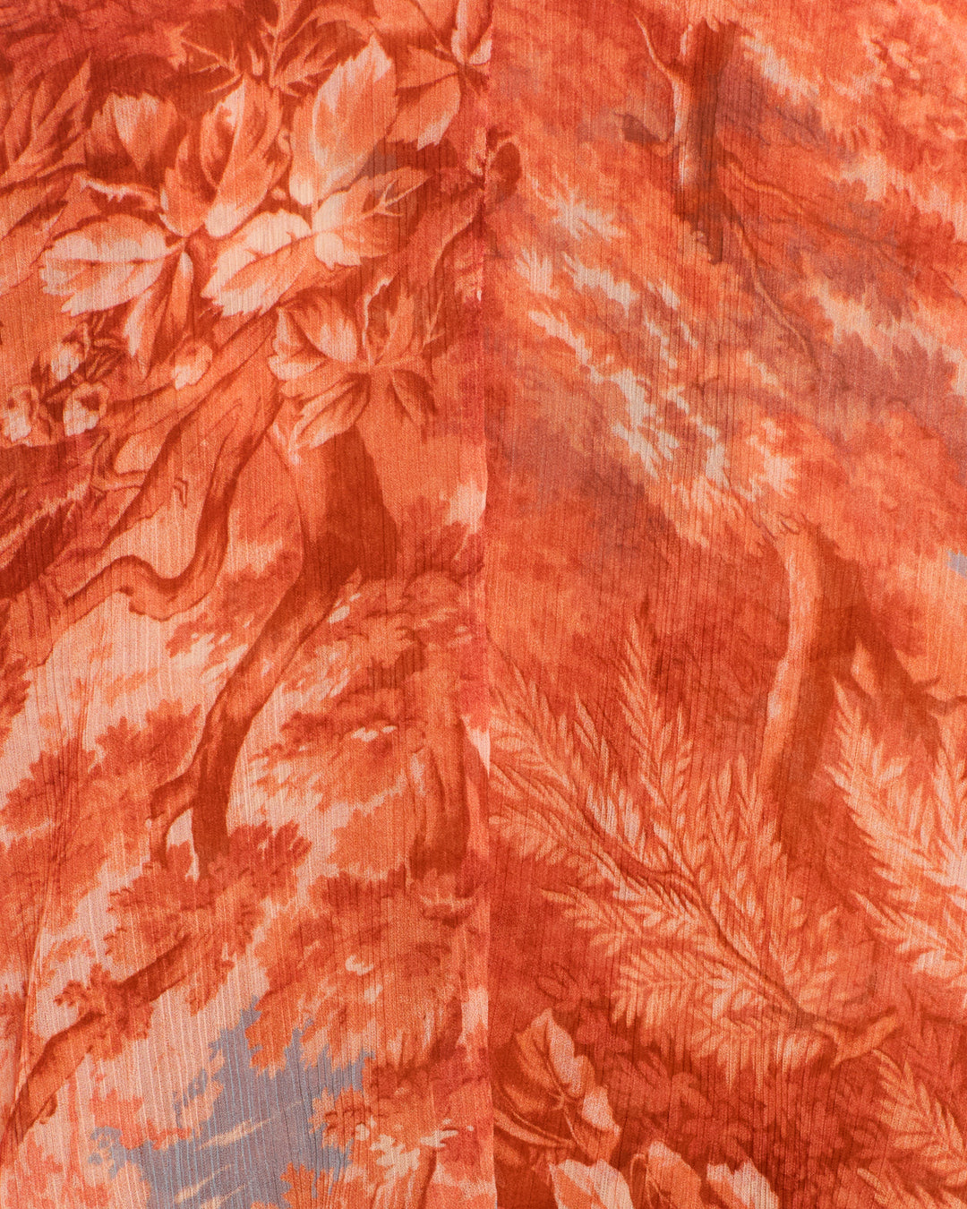 Close-up of orange and beige cupro-chiffon fabric with a detailed, nature-inspired pattern of leaves, branches, and textured lines—ideal for the Eleanor Heritage Canopy Shirt.