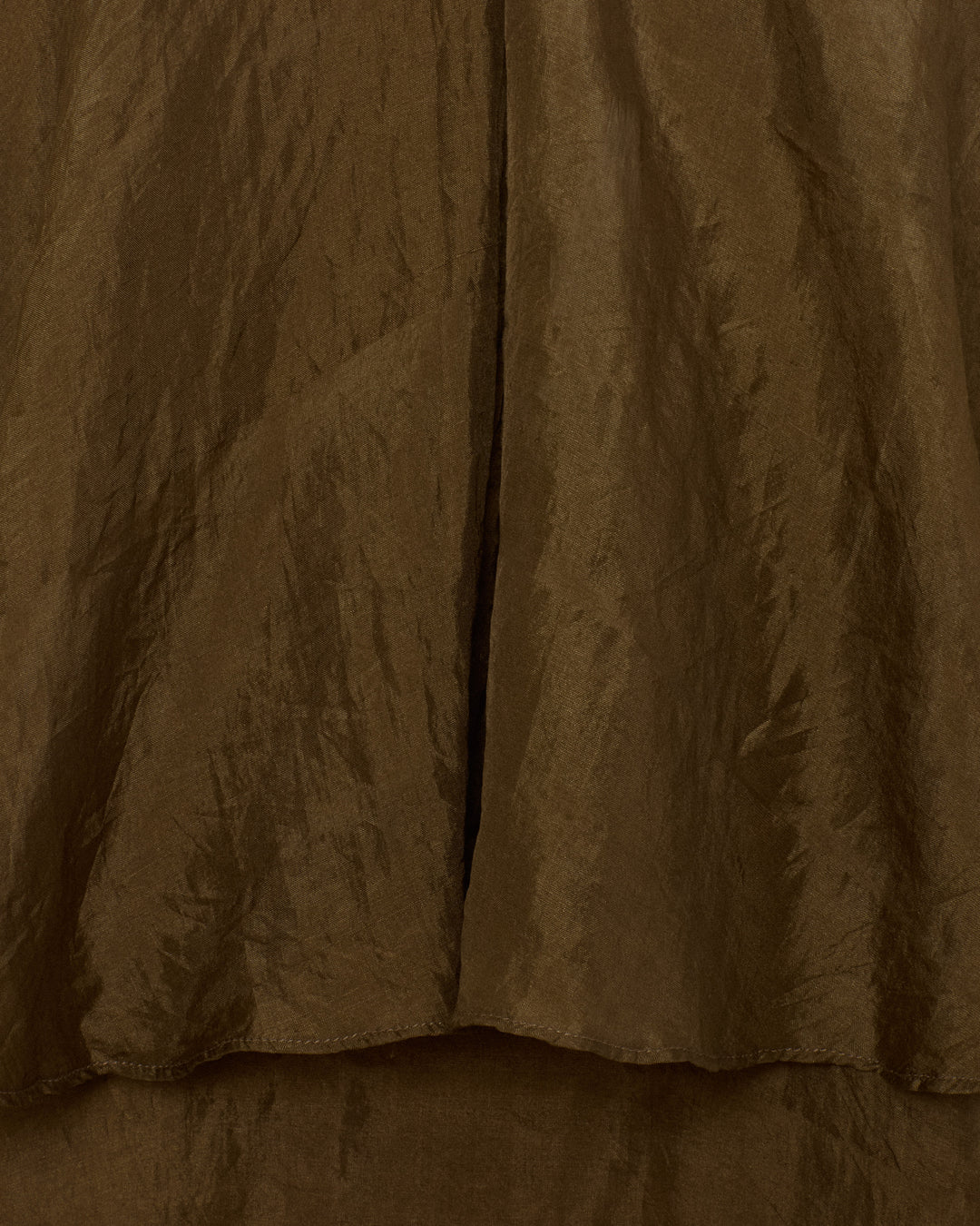 Close-up of the Eleanor Olive Silk Shirt, featuring brown, crinkled hand-loomed silk with visible texture and folds running vertically and horizontally.
