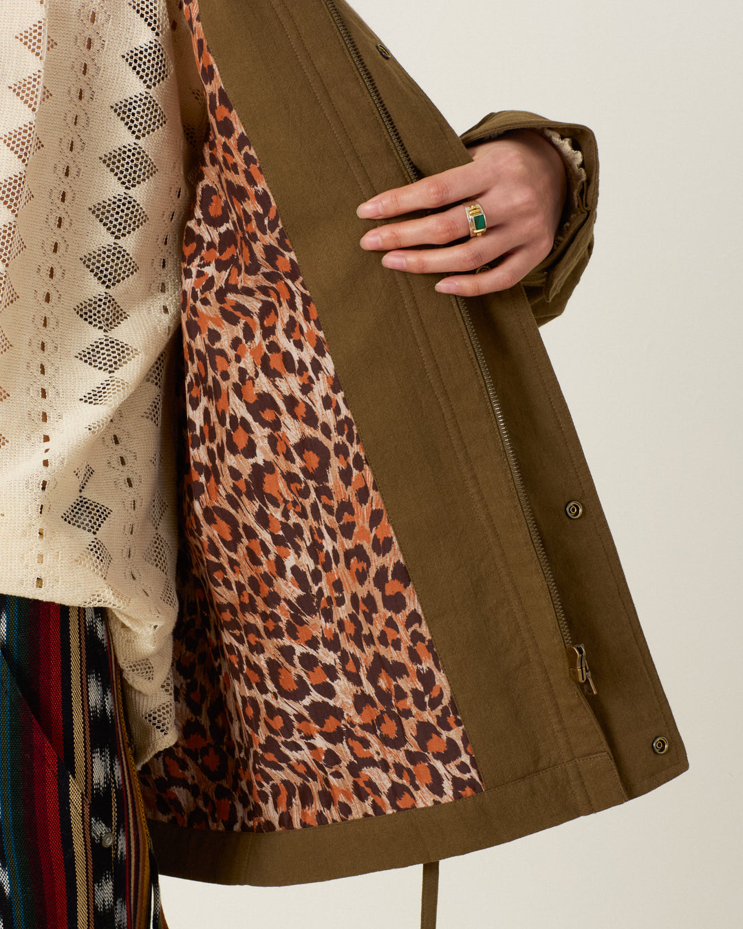 Evelyn Olive Branch Jacket in olive green with leopard print lining, worn over a cream-colored textured top.