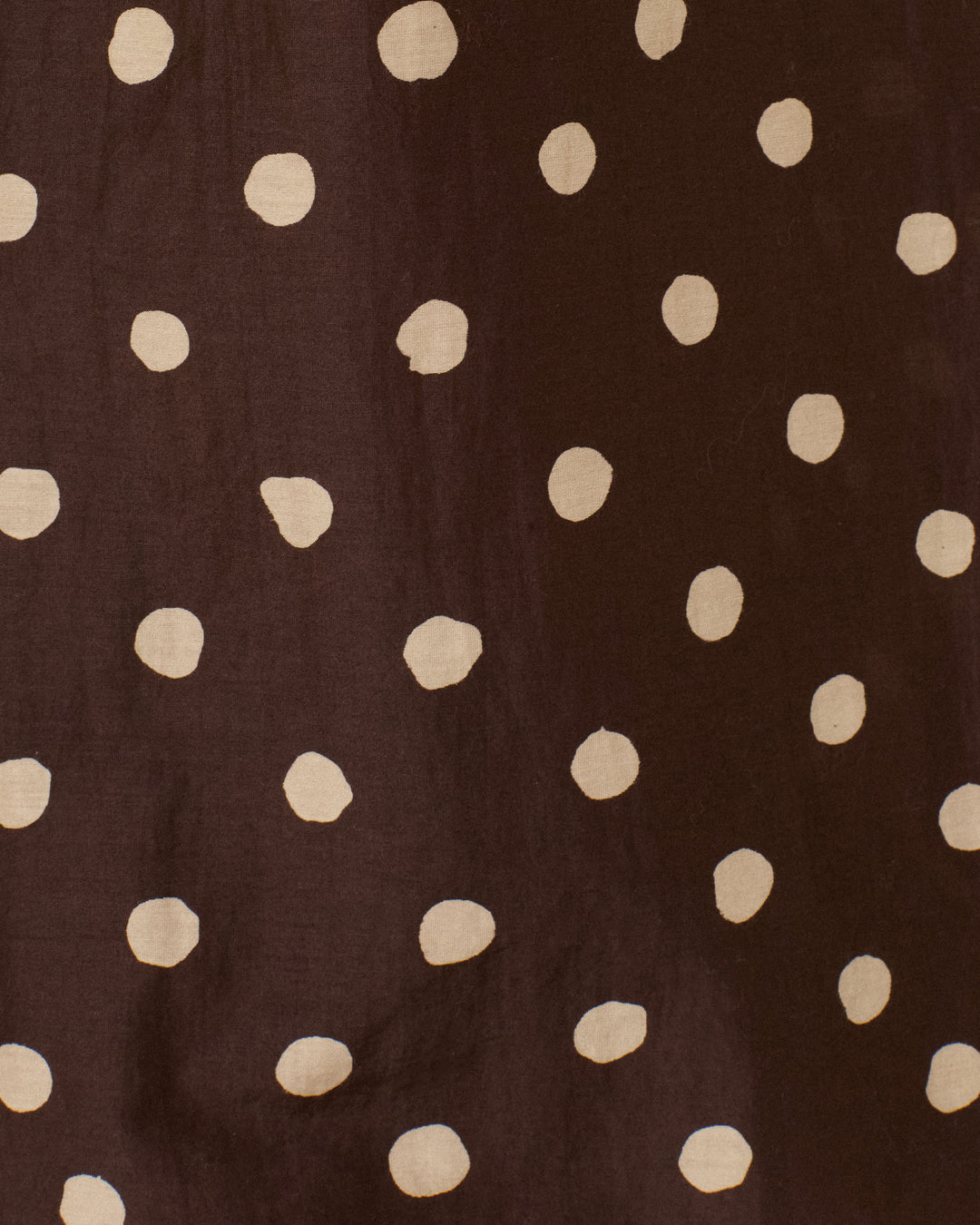 Introducing the Farah Mahogany Dot Pant, crafted from a dark brown cotton-silk blend fabric adorned with an irregular pattern of beige polka dots. Perfect for creating high-waisted silhouettes or adding a playful flair with bell-bottom styling.