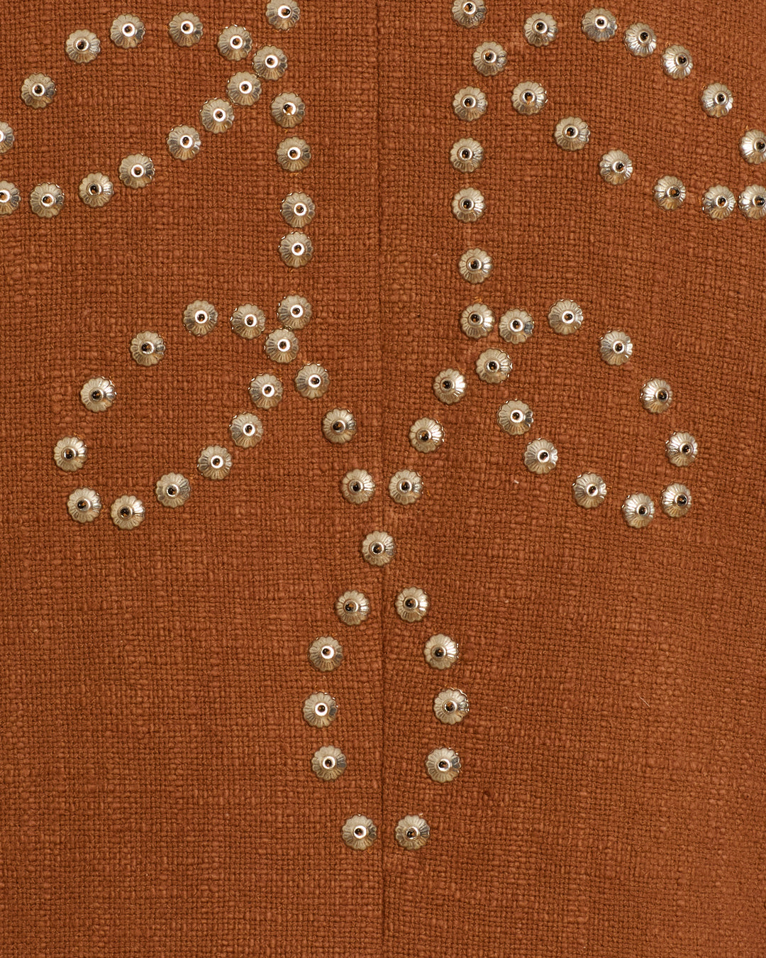 Close-up of the Petunia Fawn Stud Coat, showcasing brown textured fabric adorned with a symmetrical floral pattern created from small metallic studs—all meticulously hand-embellished for exquisite detail.