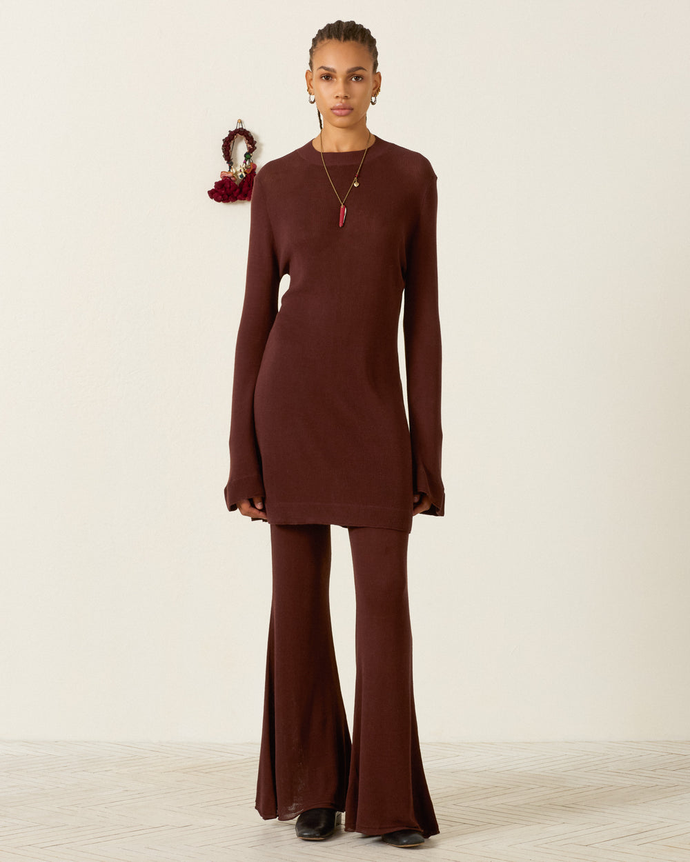 A person wearing a dark brown Romy Mahogany Knit tunic over matching flared trousers.