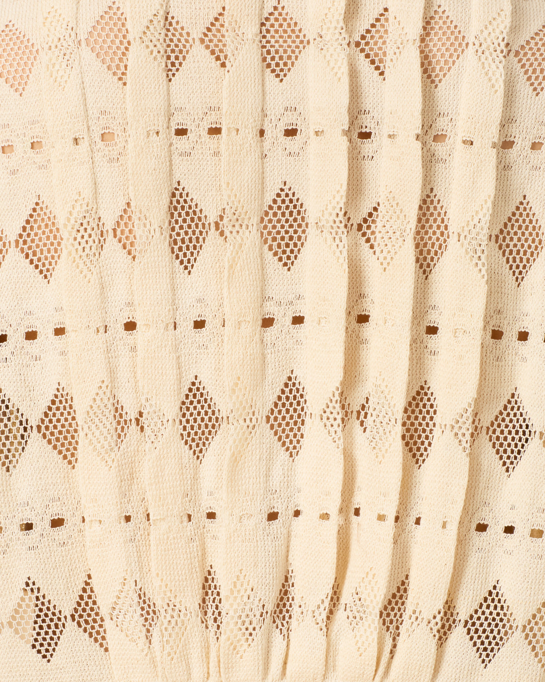 Close-up of the Ryland Savanna Lattice Shirt in beige, featuring a repeating geometric lace pattern with diamond shapes and small eyelets, accented by vertical pleats.