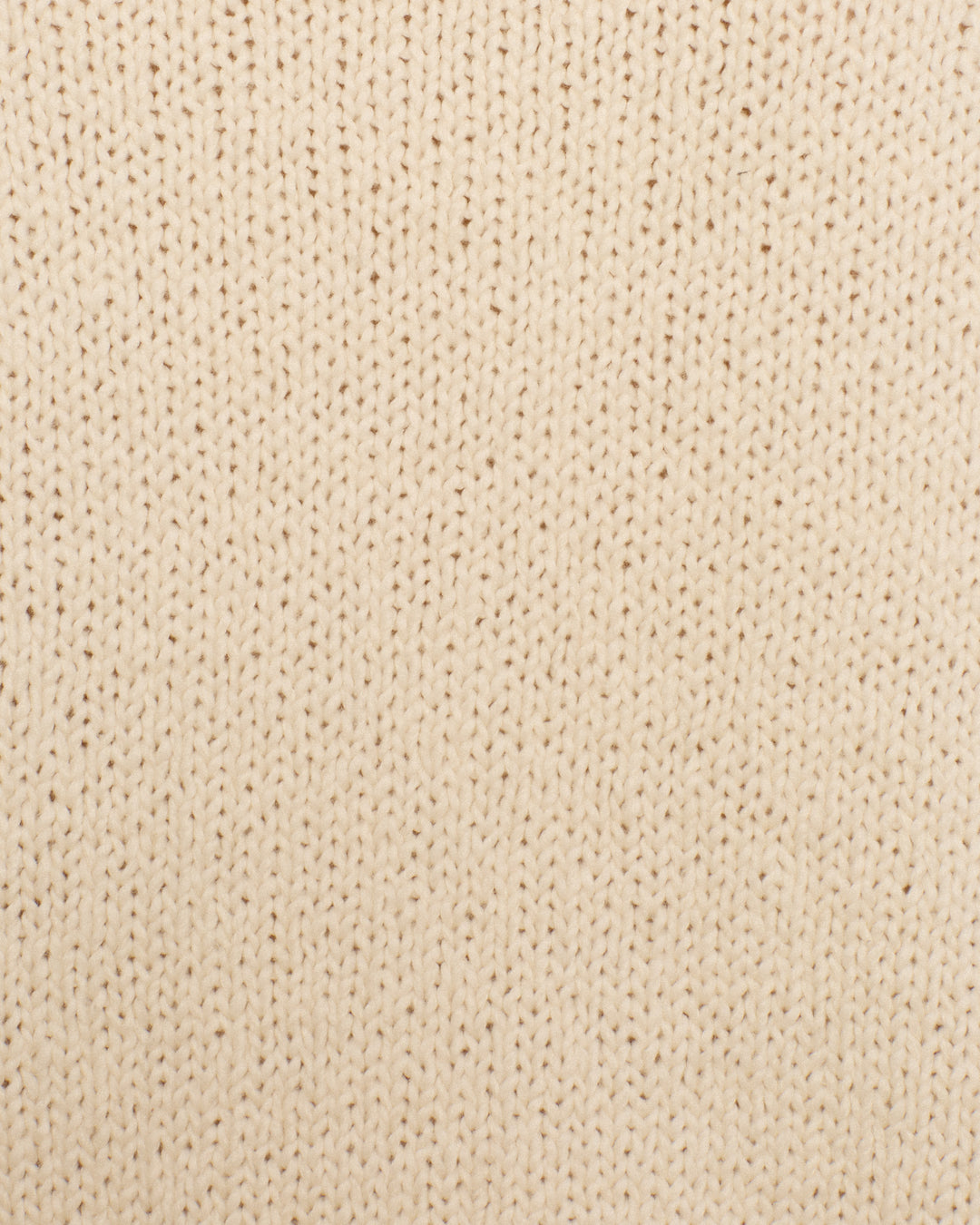 Close-up view of the Sammi Bone Fringe Cardigan, featuring a repeating pattern of vertical stitches in beige knitted fabric, crafted from soft Peruvian cotton.
