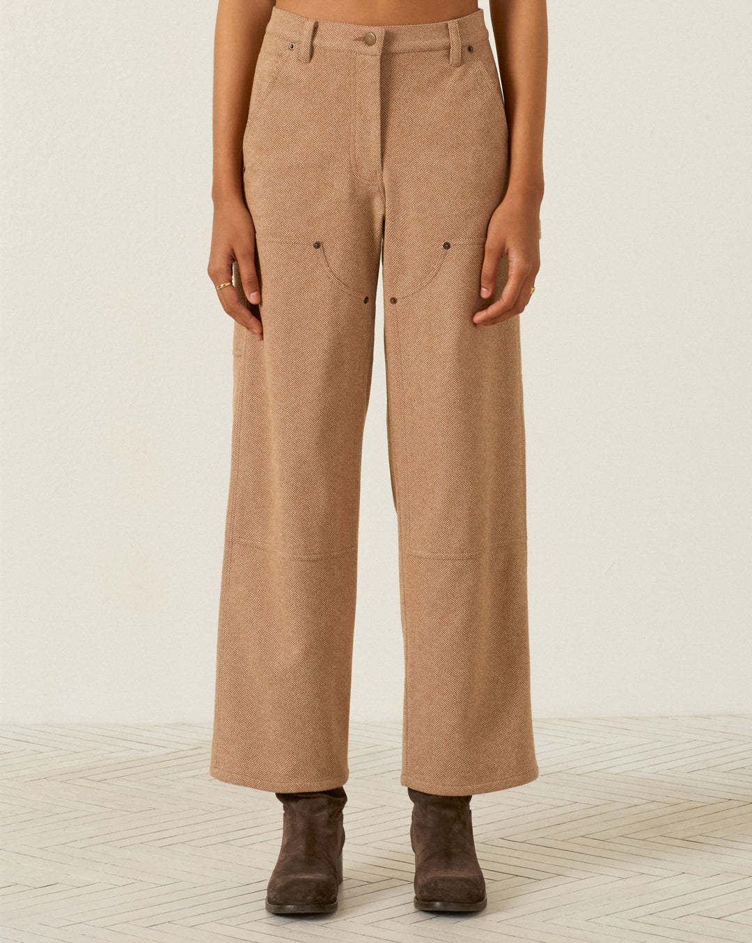 Scottie Savanna Sand pant in tan wool herringbone with front utility pockets and reinforced knee panels, worn with dark ankle boots.