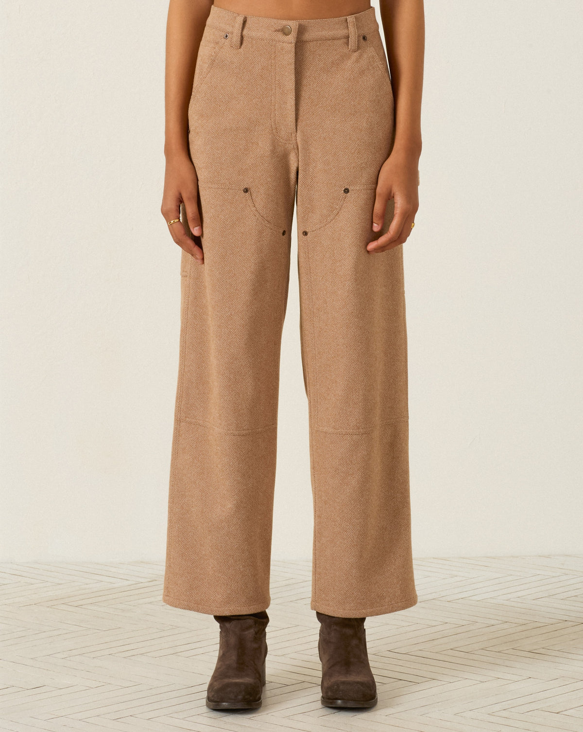Scottie Savanna Sand pant in tan wool herringbone with front utility pockets and reinforced knee panels, worn with dark ankle boots.