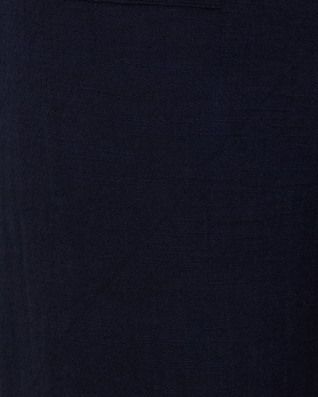 Close-up of the Sonnet Indigo Night Jean, showcasing its dark blue cotton-silk blend fabric with a visible seam or edge at the top left corner.