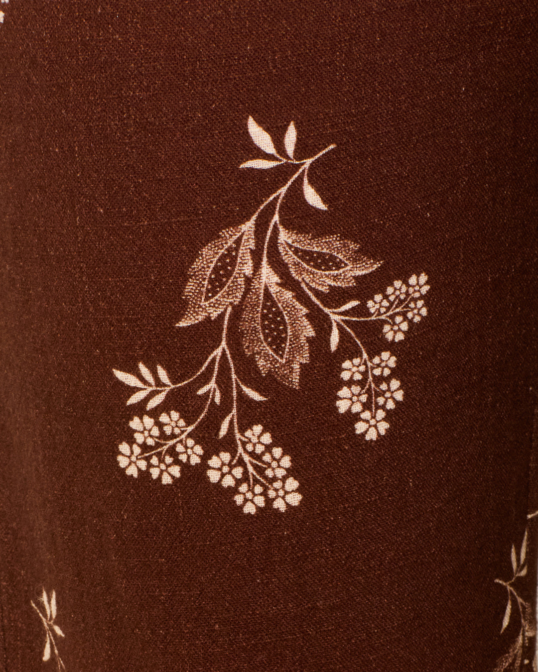 Crafted from brown cotton adorned with a cream-colored elderflower and leaf print, the Sonnet Doe Elderflower Jean is the perfect choice for creating a stylish pant with a flattering flared leg.
