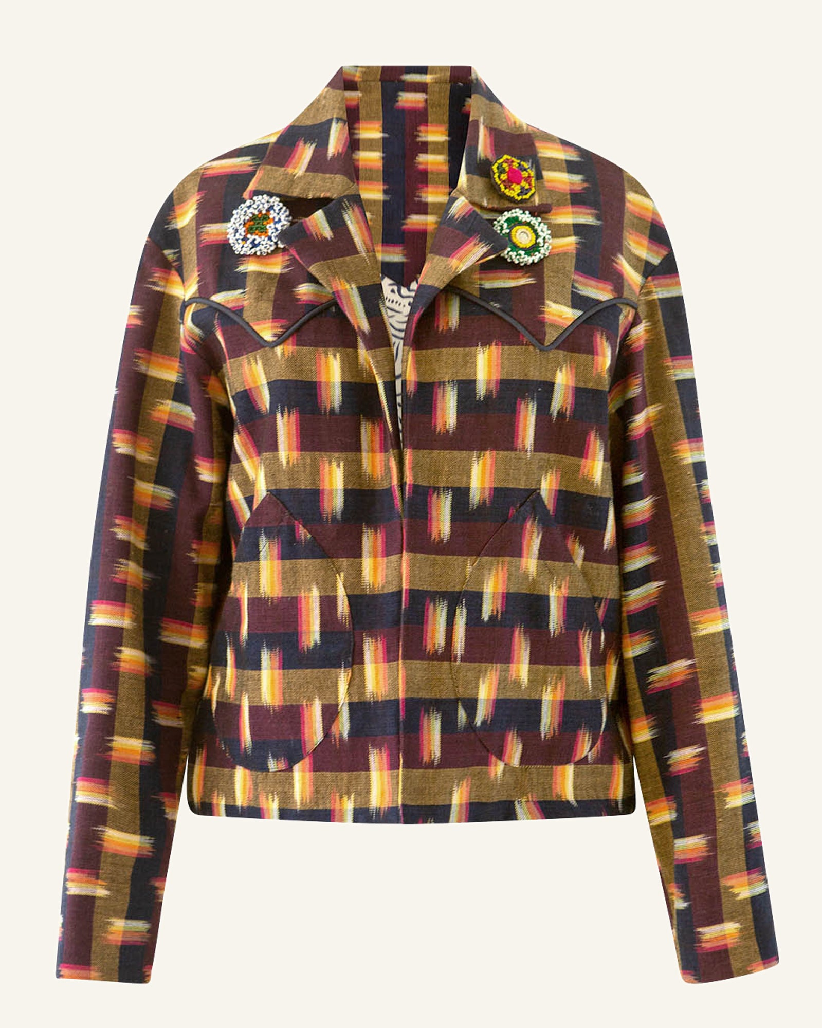 Introducing the Dune Drum Ikat Jacket, a stylish piece with a multicolor abstract stripe pattern and a relaxed fit. It boasts three decorative pins on the collar and exquisite Mother of Pearl buttons. The light, neutral background pairs perfectly with its long sleeves.