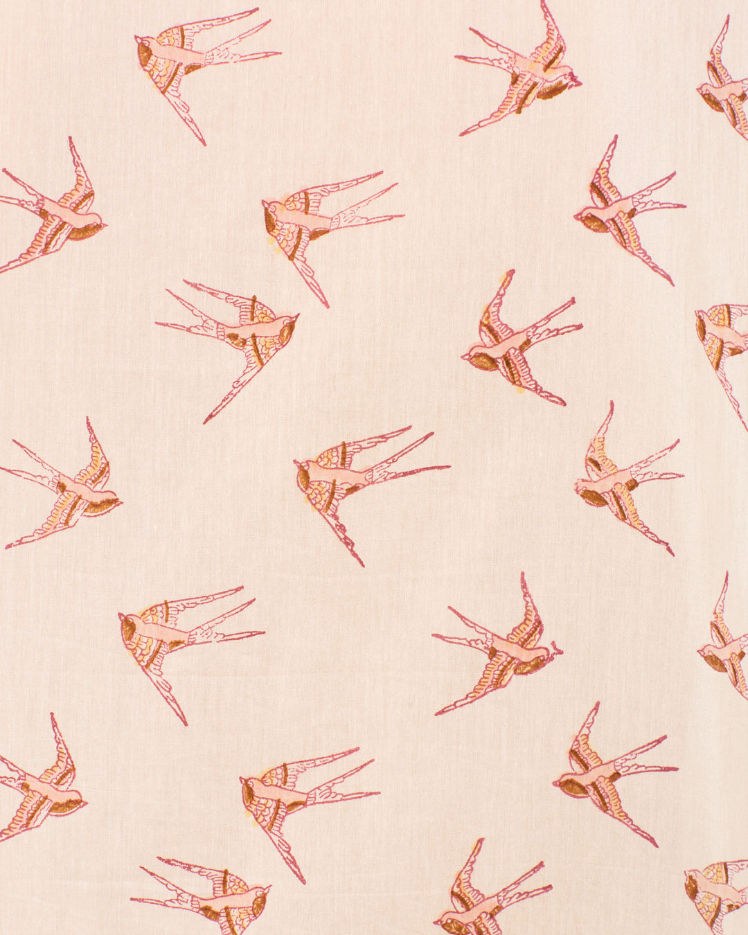 The Winnie Cedar Swallow Shirt features a light beige background with pink and orange swallows flying in various directions, inspired by traditional hand-block-printed designs.