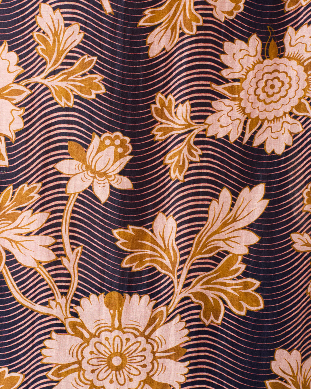 The Winn Wavy Zinnia Shirt features a floral pattern with large golden-yellow flowers and leaves on a dark backdrop, accented by wavy, parallel white lines.