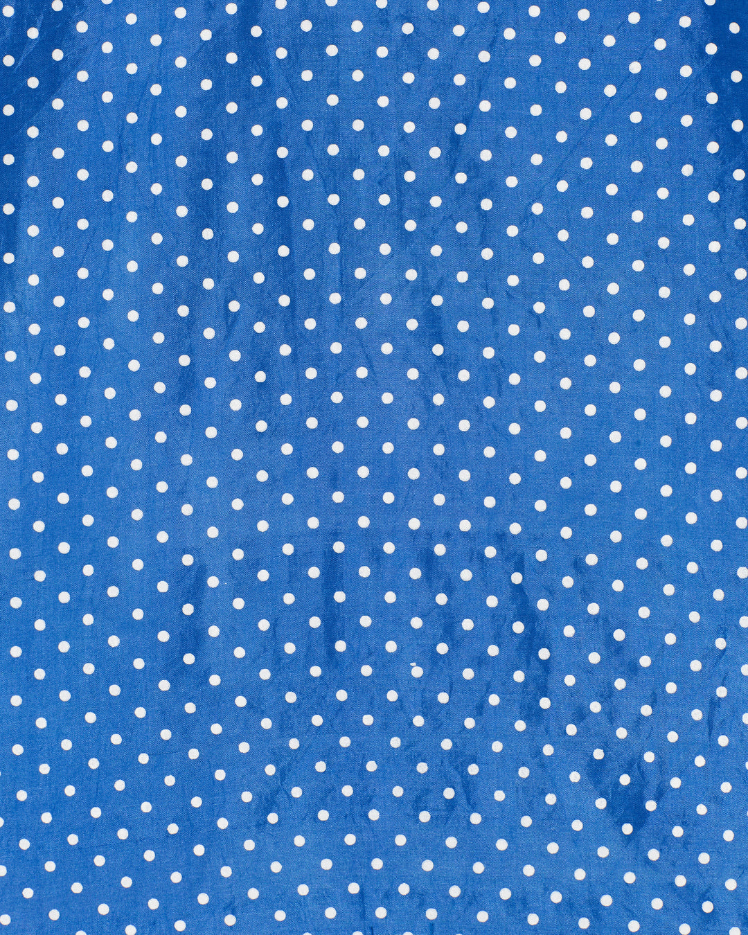 The Soleil Harbor Dot Silk Dress features blue hand-block printed fabric with a white polka dot pattern and natural creases.