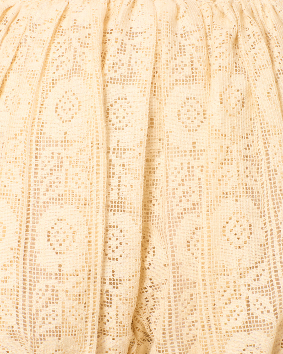 Close-up of beige lace with geometric and floral patterns and gathered elastic top—ideal for the Briar Daisy Pearl Short, which features playful bubble hems in soft cotton lace.