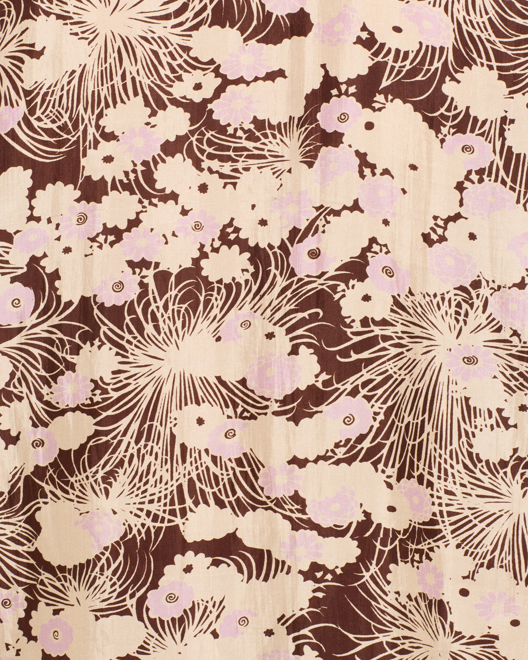 The Narene Dandelion Silk Dress features artisan weaving with beige and light pink chrysanthemum florals, swirling petals, and abstract cloud-like forms on a rich brown background.