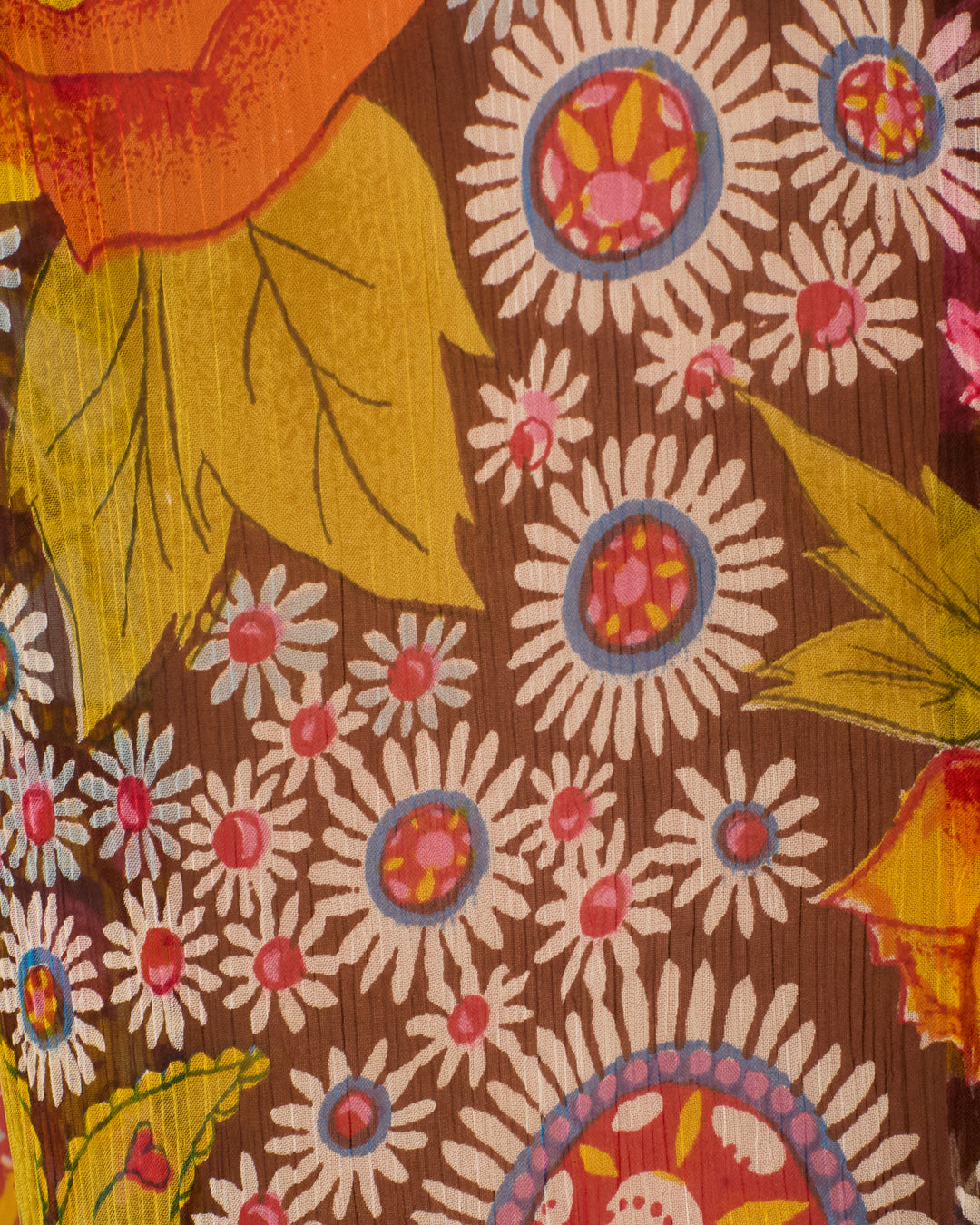 The Farah Bloom Mirage Pant showcases a psychedelic floral pattern with white daisies, pink centers, and bold yellow-orange leaves against a brown background.