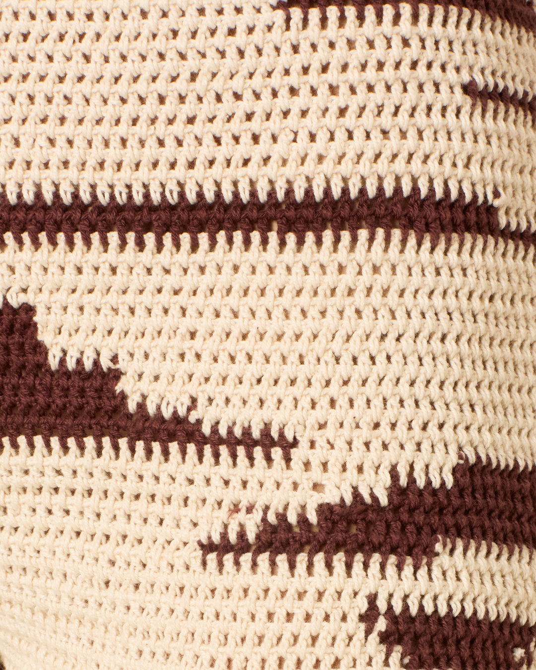 Close-up of a beige and brown crochet fabric with a zigzag pattern, reminiscent of the ikat-inspired design featured in the Farah Auburn Driftmap Pant.