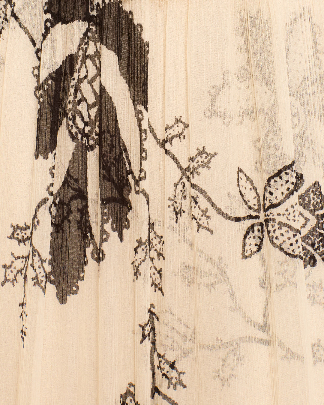 Introducing the Lilium Shadow Lace Dress—crafted from sheer beige fabric adorned with black and gray floral prints of branches and leaves in intricate, overlapping patterns, and designed in a maxi silhouette with elegant puff sleeves.