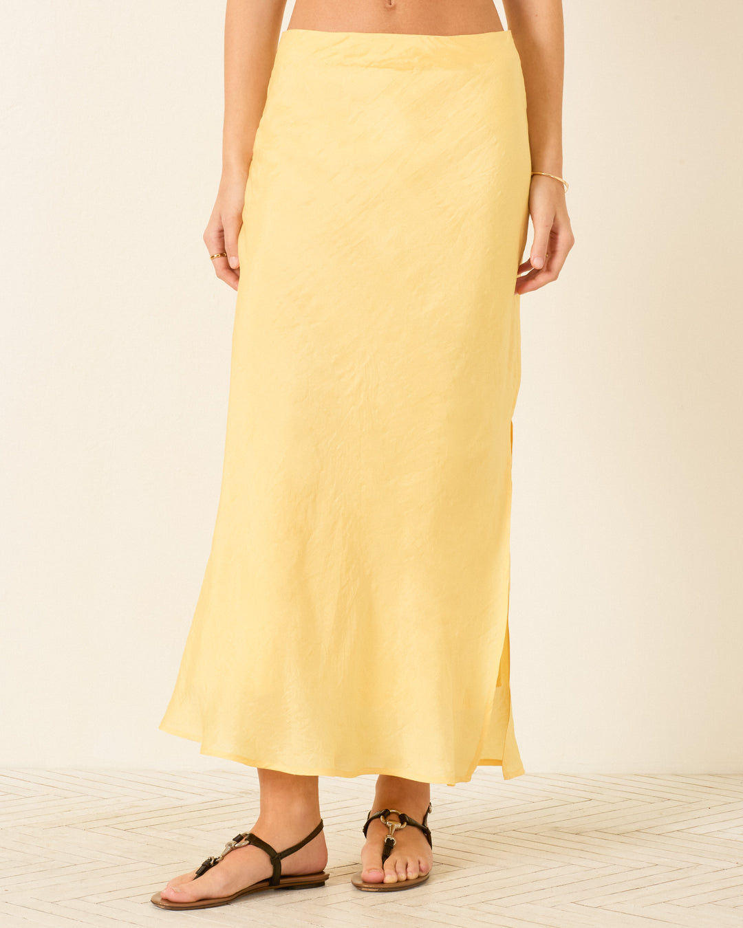 Person wearing a Lyra Sunlight Silk Skirt and black sandals, standing against a neutral background.