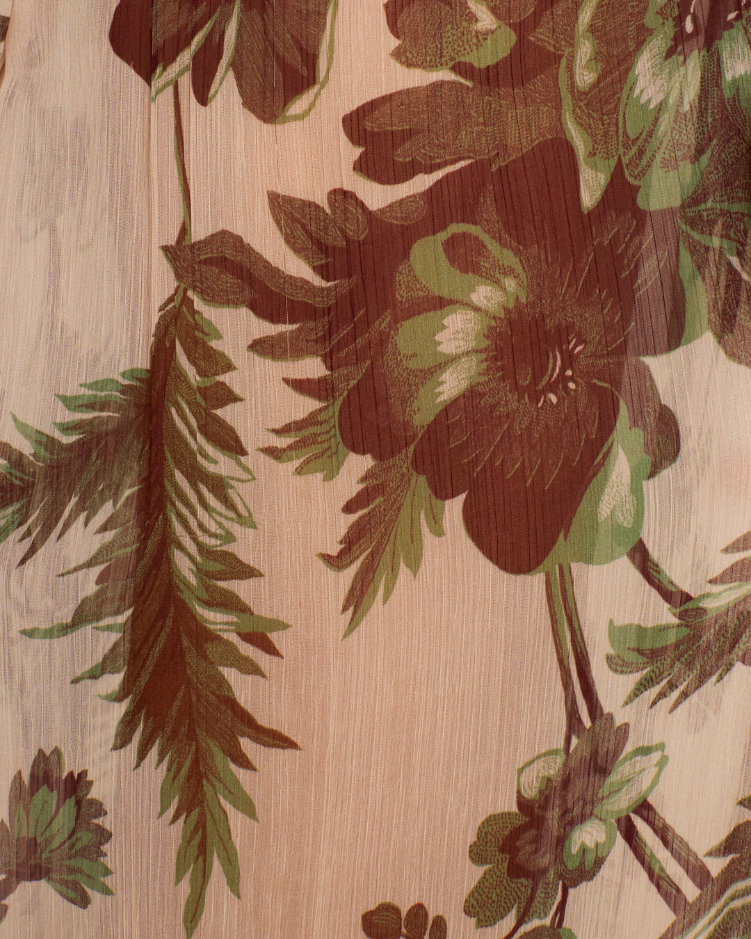Close-up of the Margot Summermoss Pant’s cupro-chiffon fabric, featuring a brown and green botanical motif on a beige background.
