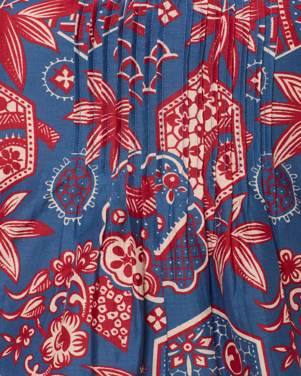 Close-up of the Mimi Delft Hive Top: a blue cotton-silk blend with red and white wagara print featuring flowers, leaves, and hexagons—ideal for a cropped look.