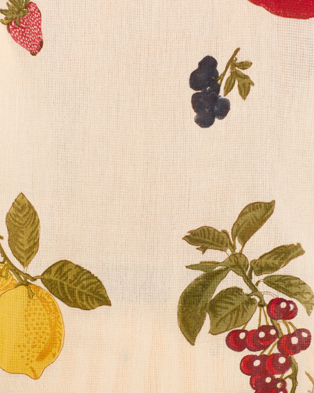 The Poet Nine Fruit Blouse showcases a charming printed fruit pattern with lemons, strawberries, blueberries, and cherries on a light background—perfect for adding a playful touch to your wardrobe.