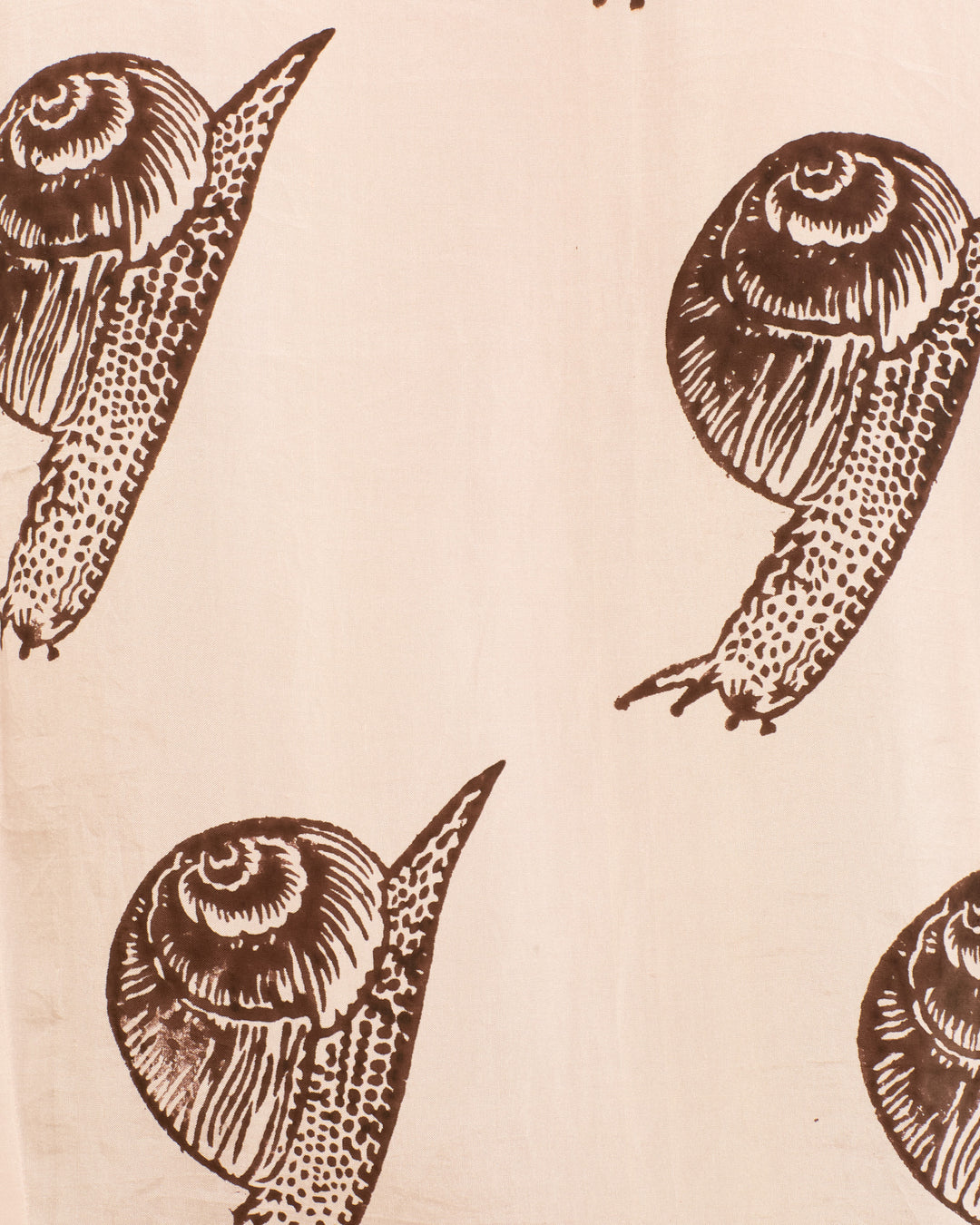 Illustration of brown snails with spiral shells on a light beige background, repeated in a simple, evenly spaced pattern—perfect for the Soraya Snail Study Silk Sarong.
