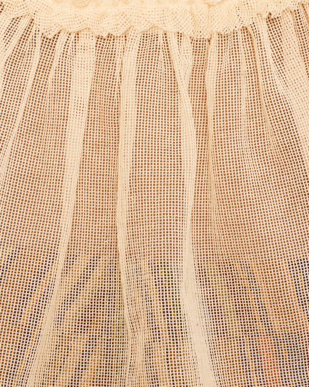 Close-up of the Tati Pearl Weave Top: a light beige cotton mesh design with vertical pleats, gathered top edge, and delicate ruffled trim.