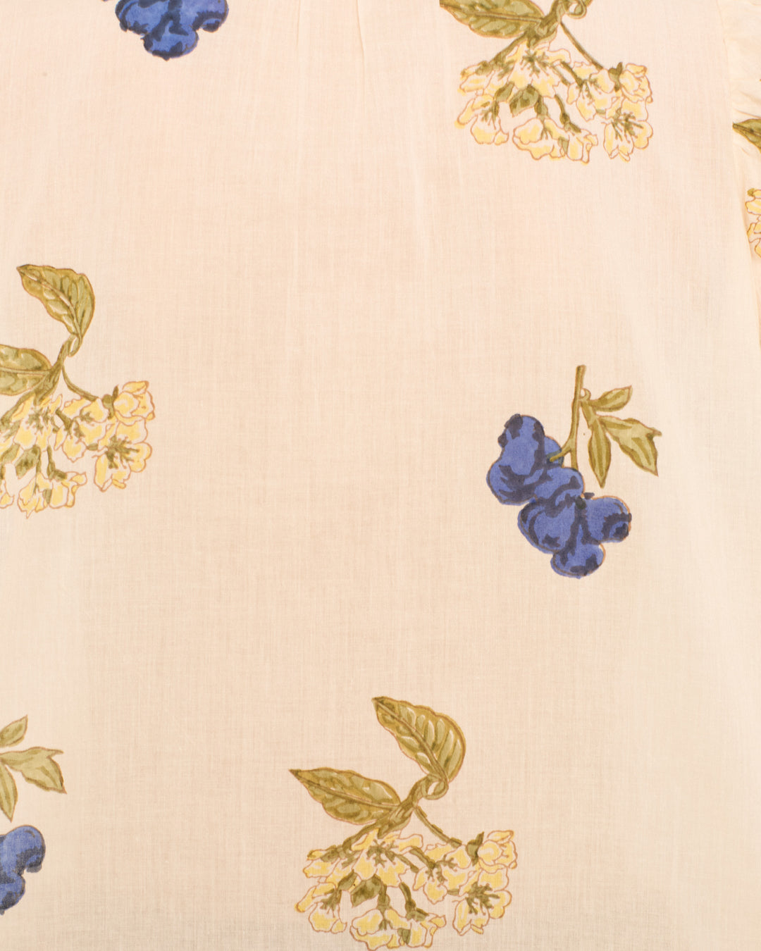 The Winnie Blueberry Flora Shirt features an off-white fabric adorned with a repeating pattern of yellow flowers and blue fruit clusters with green leaves, arranged in a scattered, hand-block-printed style reminiscent of classic cotton voile shirts.