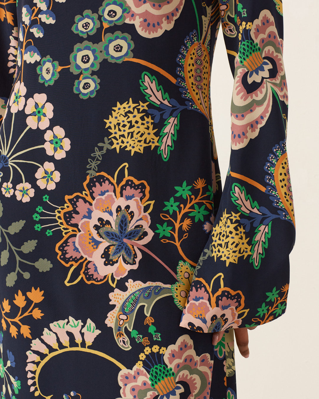 Close-up of the Nia Desert Flower Dress sleeve, featuring a vibrant Liberty-print floral pattern with various flowers and leaves on a dark background.