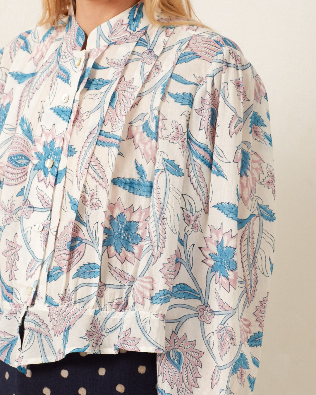 Close-up of a person wearing the Ryland Blue Valentine Shirt, showcasing its floral pattern with blue and pink designs and intricate hand-block printed details.