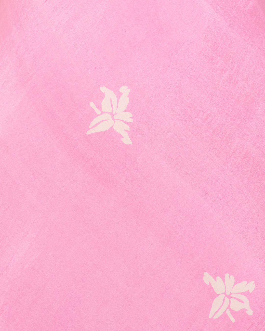 The Adele Pink Jasmine Dress features light pink hand-loomed silk with a subtle texture and two small white hand-block-printed jasmine floral motifs spaced apart.