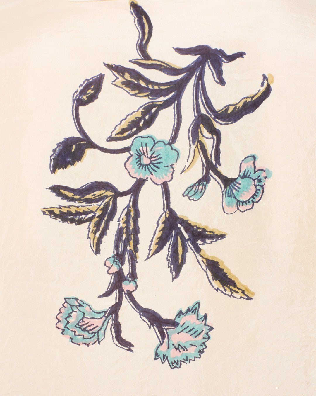 The Dana Misted Lily Silk Shirt showcases a delicate floral design with blue and pink lilies and green leaves set against a light beige background.