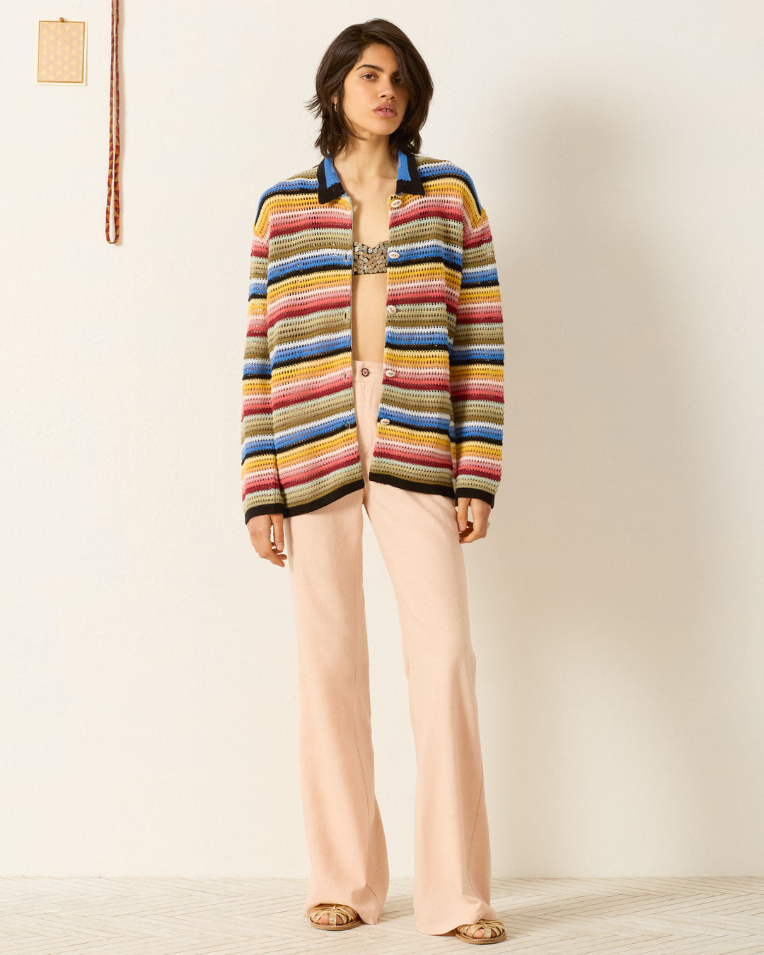 Indoors, a person wears the Emery Ombre Crochet Top paired with light pink wide-leg pants and sandals.