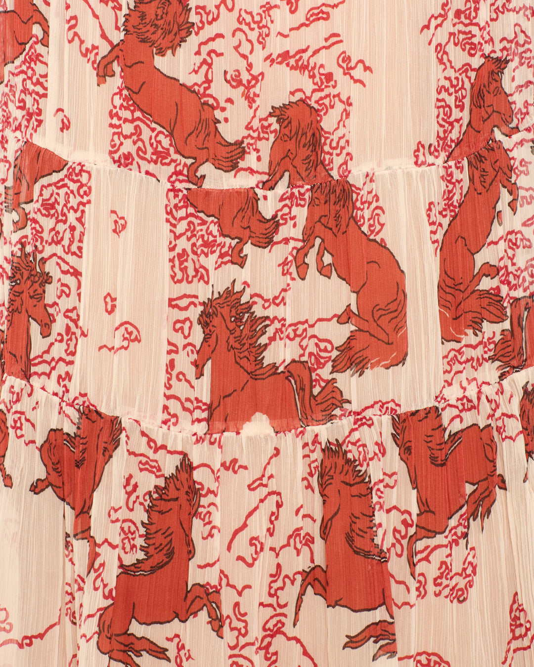 Close-up of the Juno Rouge Pegasus Dress fabric, showcasing red pegasus motifs in motion against a light background.