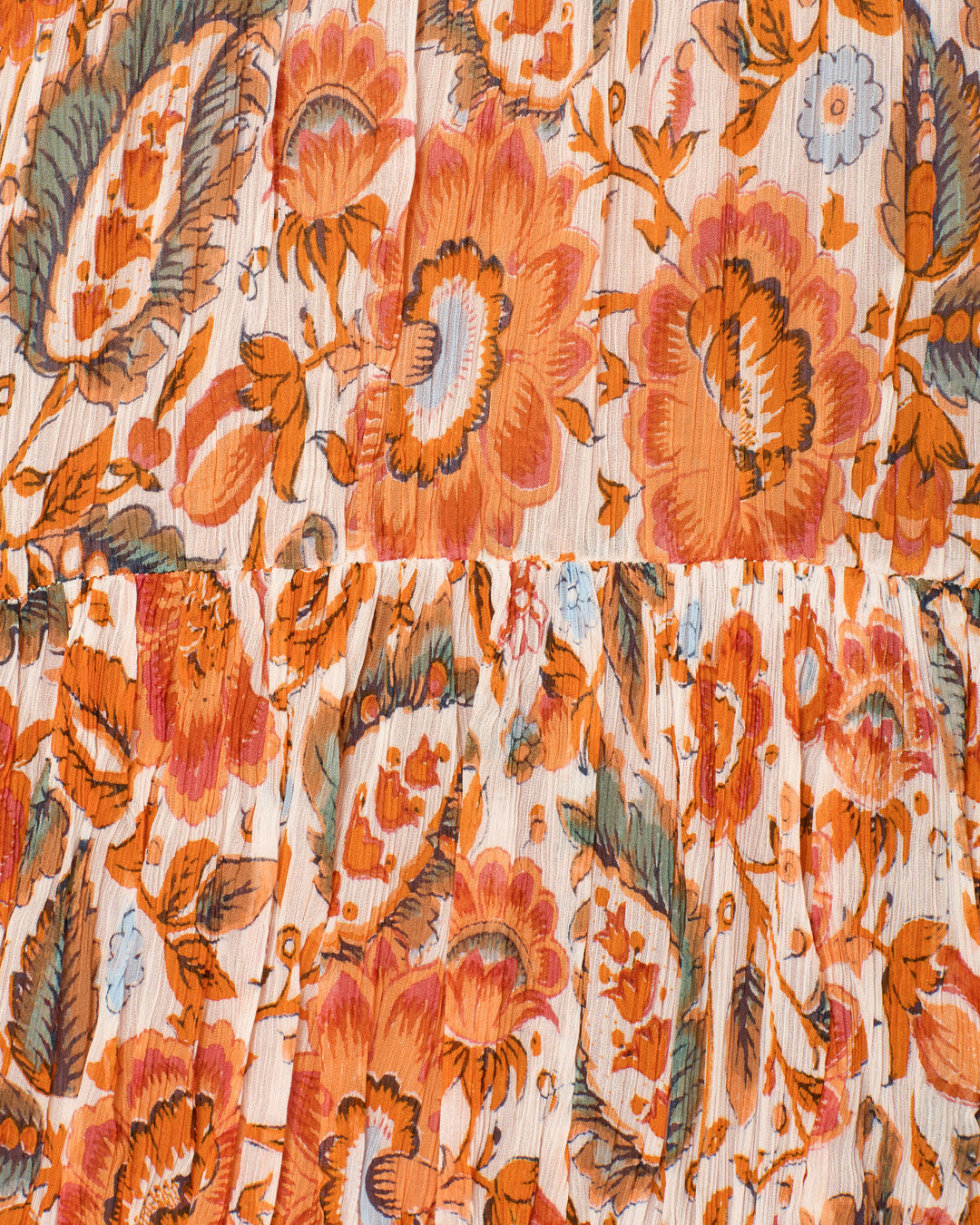 Close-up of the Lilium Topaz Flower Dress fabric, featuring an orange and green floral pattern on white with a horizontal seam—ideal for pleated empire waist maxi dress styles.