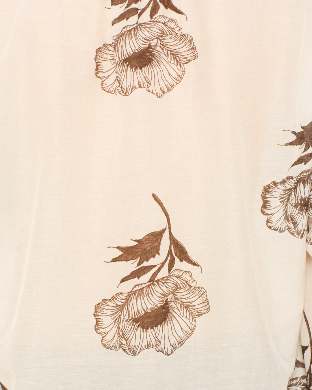 Close-up of the Kiki Obsidian Poppy Shirt's hand-block-printed light beige cotton-silk fabric, featuring large, detailed brown flowers and leaves—ideal for an Edwardian-inspired silhouette.