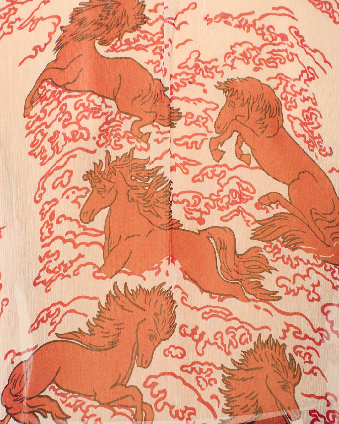 The Poet Rouge Pegasus Blouse features five reddish-brown horses, inspired by mythical motifs, galloping and leaping among swirling red clouds on a beige background.