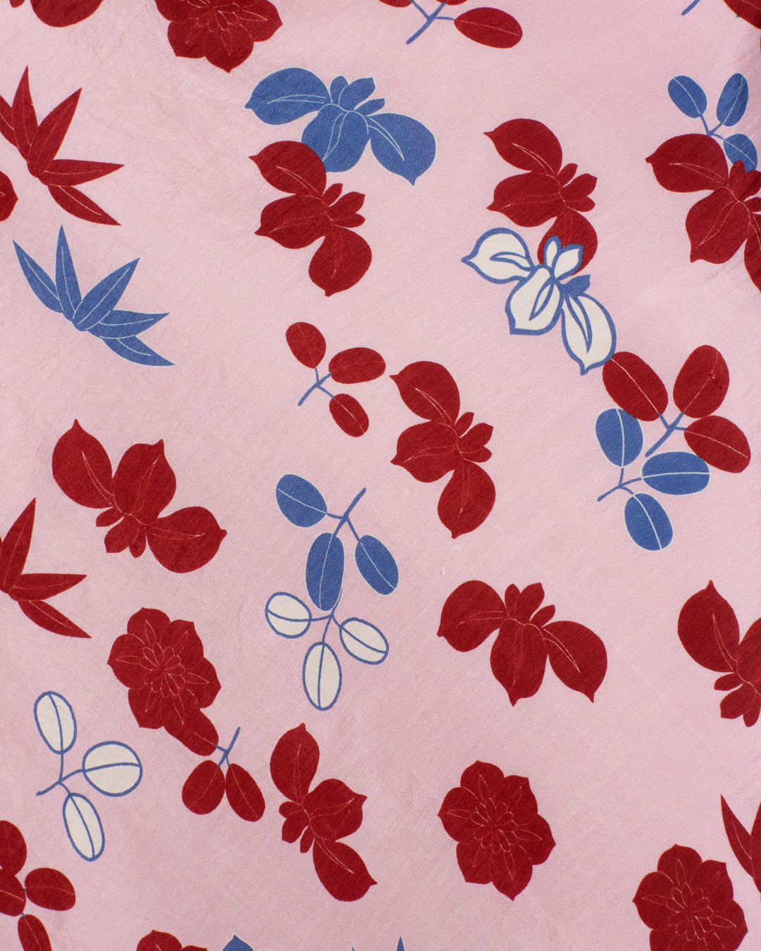 The Adele Tutu Bloom Silk Dress features a kimono-inspired botanical motif with red and blue floral and leaf patterns scattered over a light pink fabric background.
