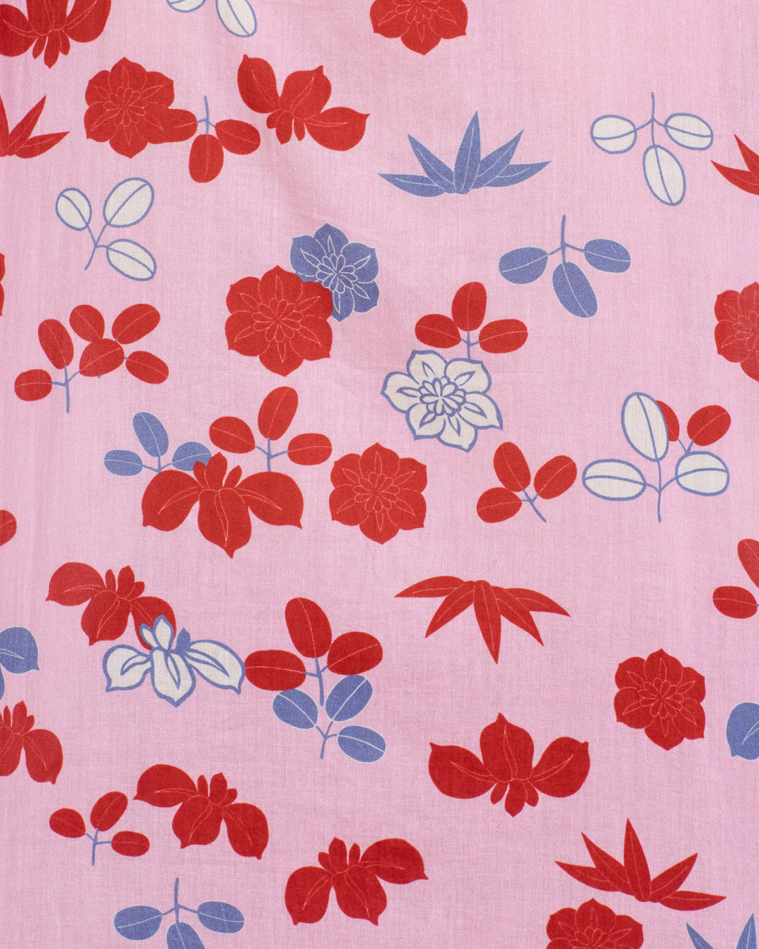 The Annabel Tutu Bloom Shirt is a cotton voile top with red, blue, and white botanical and leaf patterns on pink. Puff shoulders add charm to its regular repeating motifs.