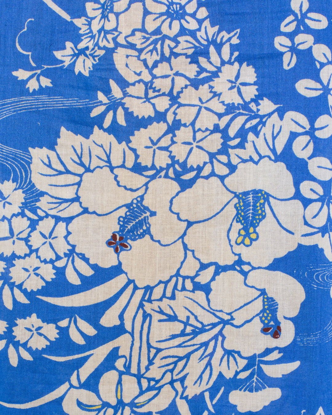 The Artemis Royal Spoke Shirt features blue cotton voile fabric with a white floral pattern, highlighted by large flowers, leaves, and small red, yellow, and blue accents—ideal for a ruffled collar look.