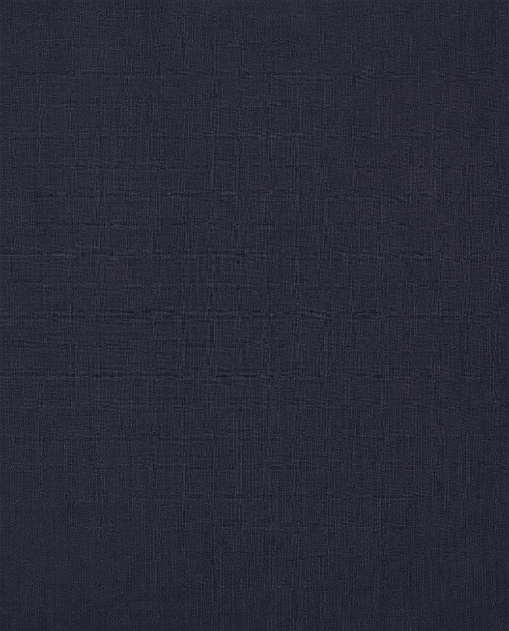 A dark navy blue fabric surface with a subtle, fine texture extends across the entire image—evoking the refined materials featured in the Artemis Deep Sea Shirt and its delicate puff sleeves.