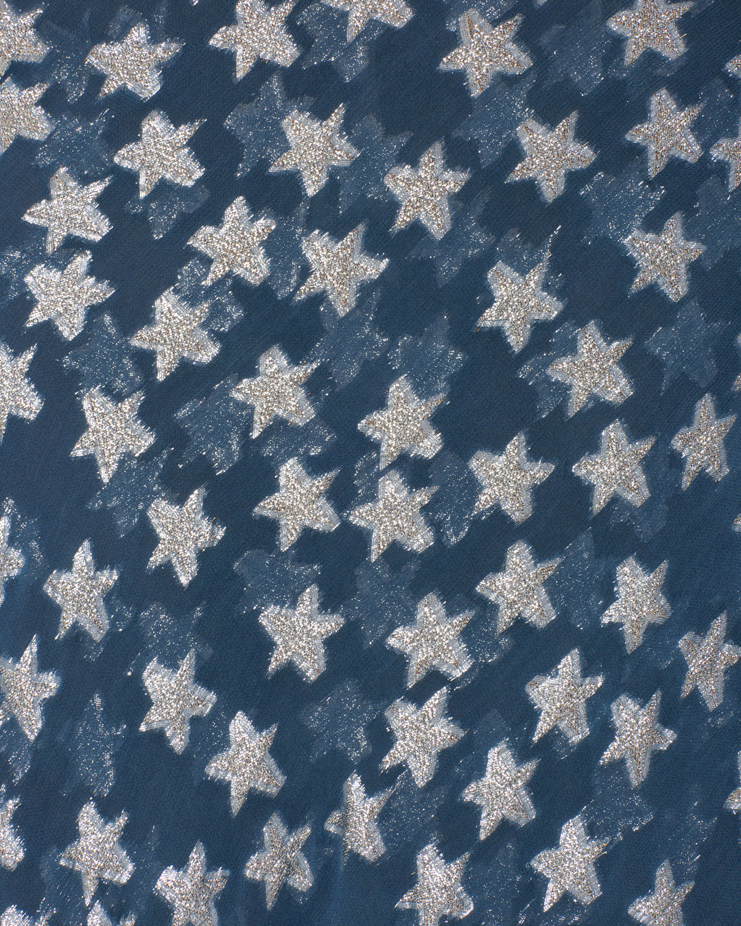 Close-up of the Athens Starlite Dress fabric, featuring white glittery stars patterned on a dark blue background, inspired by metallic silver fil-coupé on elegant viscose-chiffon.