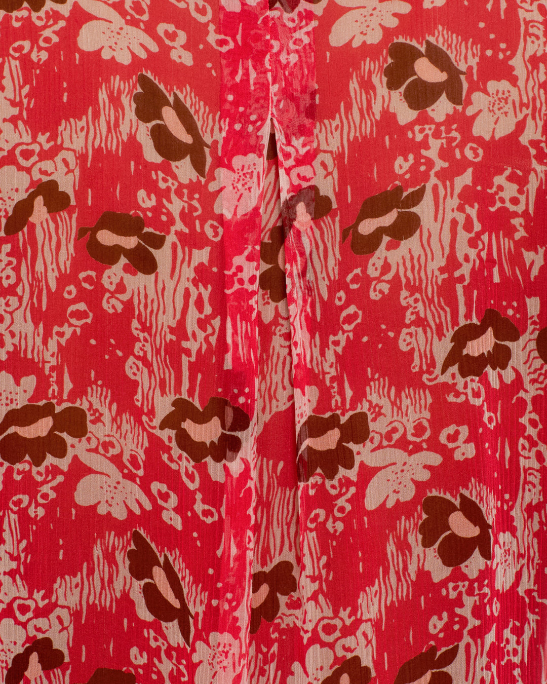 Close-up of the Chancery Rougewood Shirt's pink fabric, showcasing a brown and light pink '70s floral motif with a central stitched seam. The abstract vintage-inspired design echoes classic semi-sheer blouses.