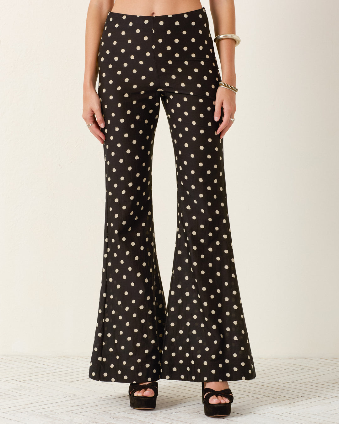 A person wearing Farah Blanc Speckle Pant with black platform heels, a bracelet, and a bangle stands against a plain background.