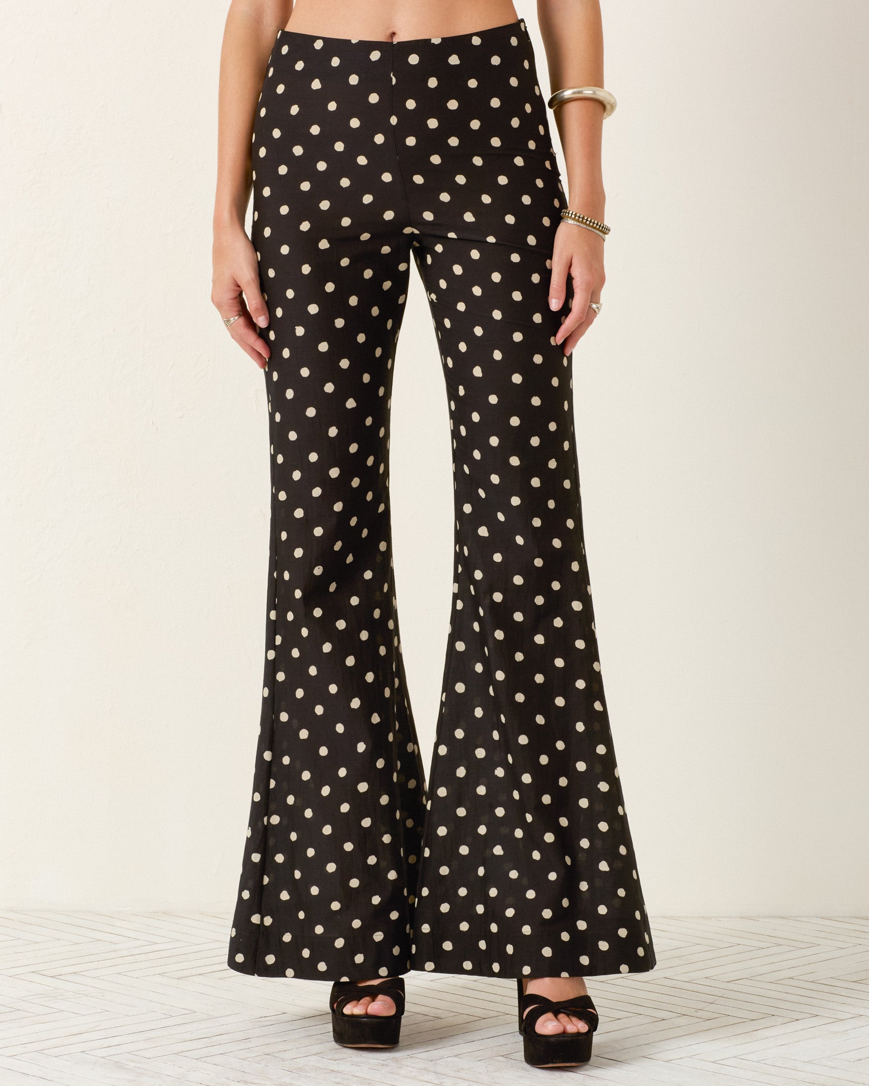 A person wearing Farah Blanc Speckle Pant with black platform heels, a bracelet, and a bangle stands against a plain background.