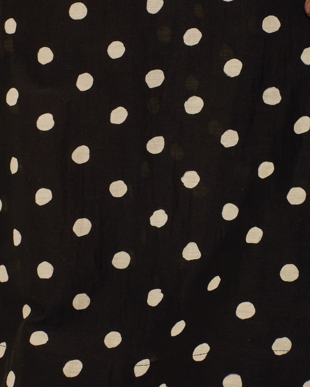 The Farah Blanc Speckle Pant features black fabric with an irregular polka-dot pattern, ideal for crafting chic high-waisted pants or adding flair to a bell-bottom silhouette.