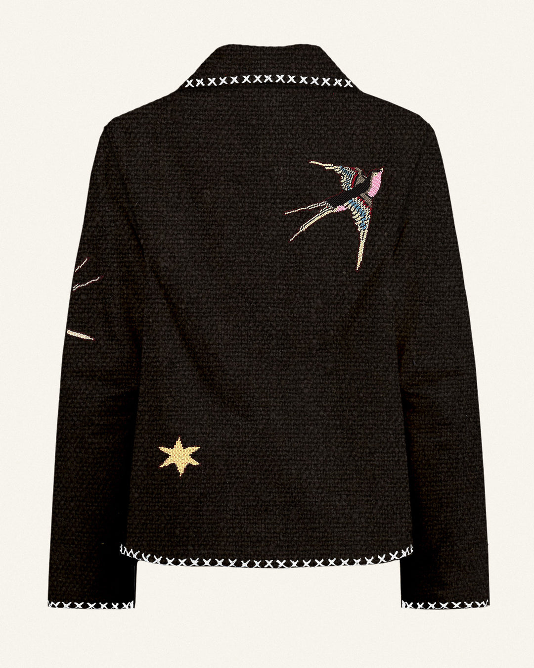 The Francis Black Tattoo Jacket features white cross-stitch trim, an embroidered swallow on the back, a yellow star on the lower left side, and partial embroidery on the left sleeve.