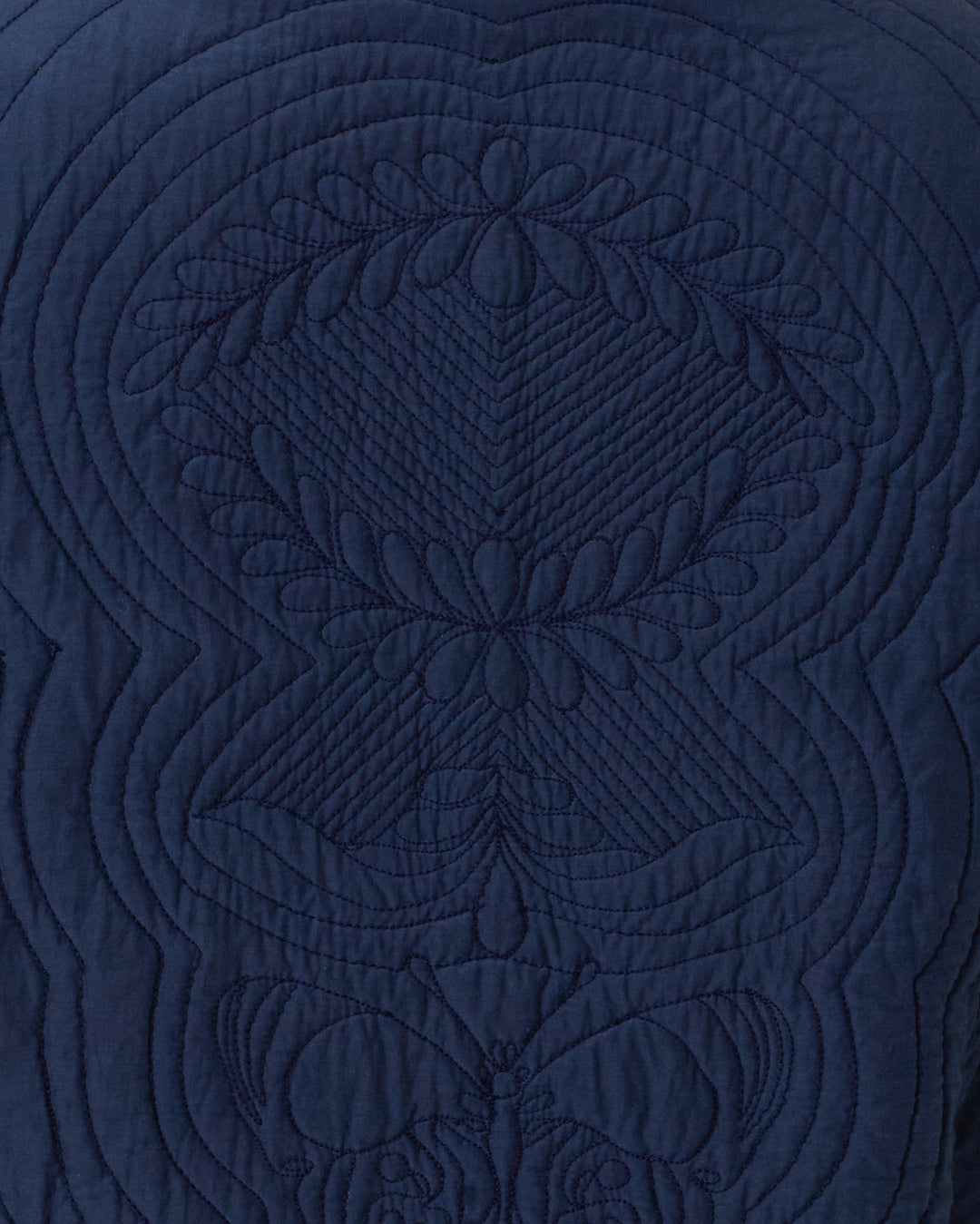 Close-up of Jude Midnight Reverie Jacket’s dark blue cotton-silk fabric, featuring symmetrical quilted leaf and geometric motifs with intricate stitching.