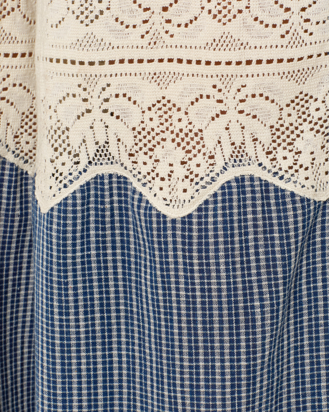 Close-up of white floral cotton lace layered over blue-and-white checkered Khadi cotton, featured in the Margie Prima Micro Plaid Pant—ideal for crafting a unique wide-leg look.