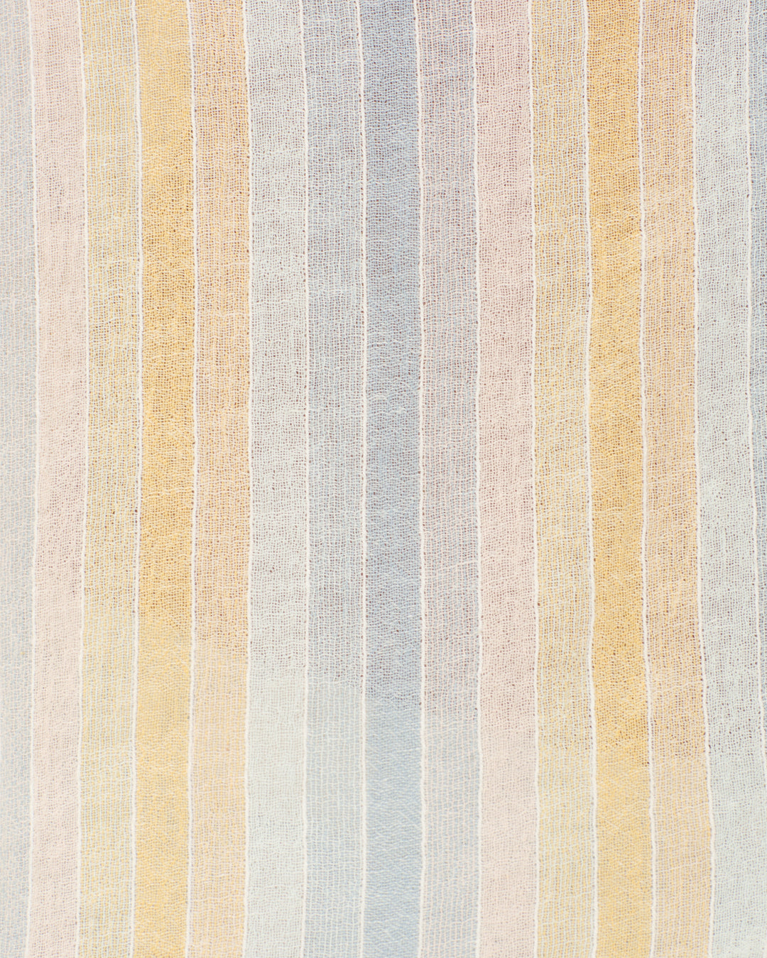 Close-up of the Poet Sunwash Stripe Blouse, made from gauzy cotton with soft, slightly sheer texture. Features vertical pastel stripes in yellow, blue, pink, and white.